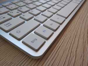 white computer keyboard on brown wooden table
